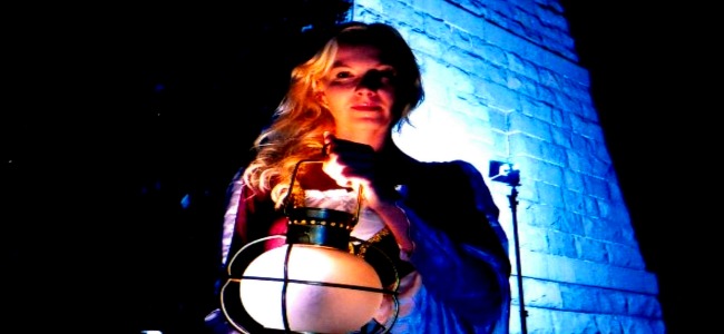A lady with a lantern leading one of the city ghost tours.