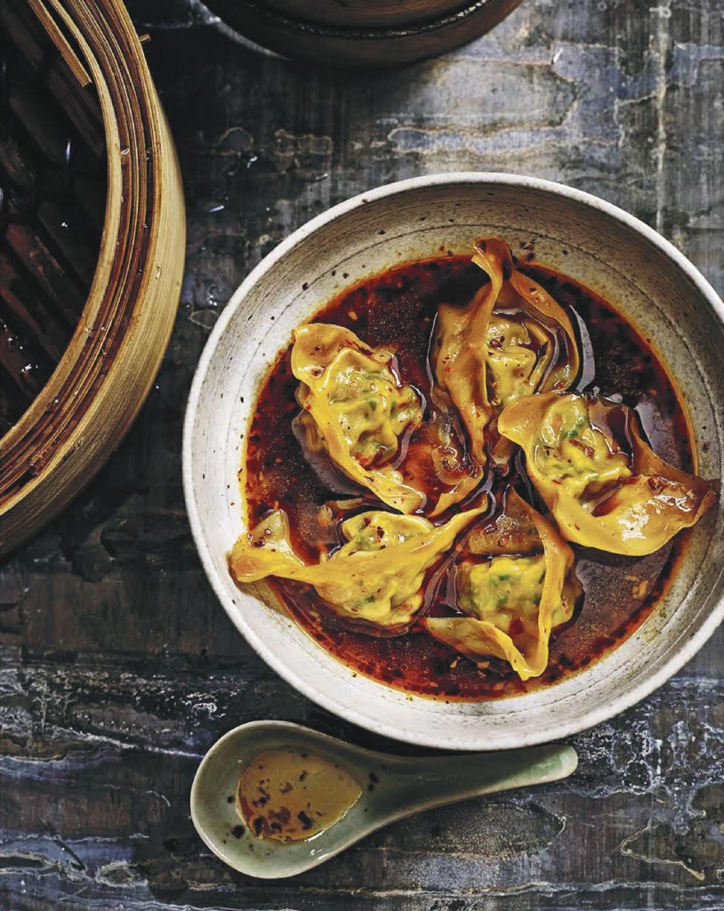 Steamed wontons with chilli broth in a bowl, spoon on the side